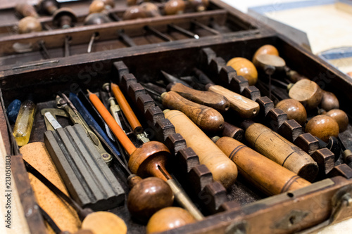 Antique tools for engraving and printing in a wooden case. Tools for typographers and artists to make prints, lithographs, etchings and engravings. Ancient art and craftsmanship photo