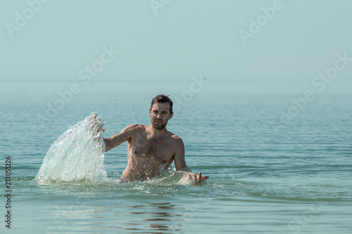 Splashing sea water, a guy in the sea
