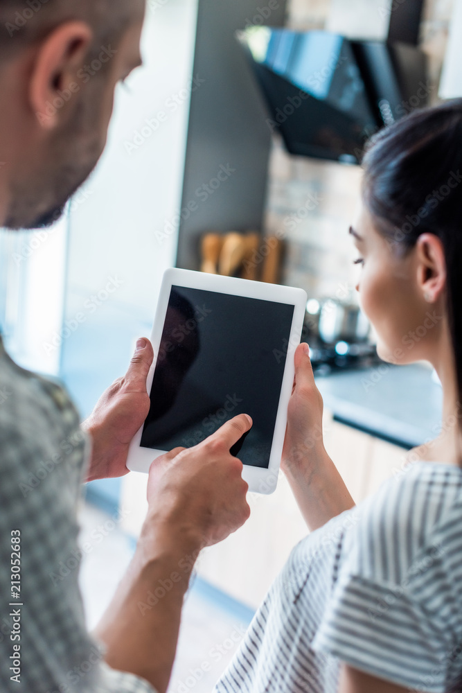 partial view of married couple using digital tablet with blank screen together at home, smart home concept partial view of married couple using digital tablet with blank screen together at home, smart home concept