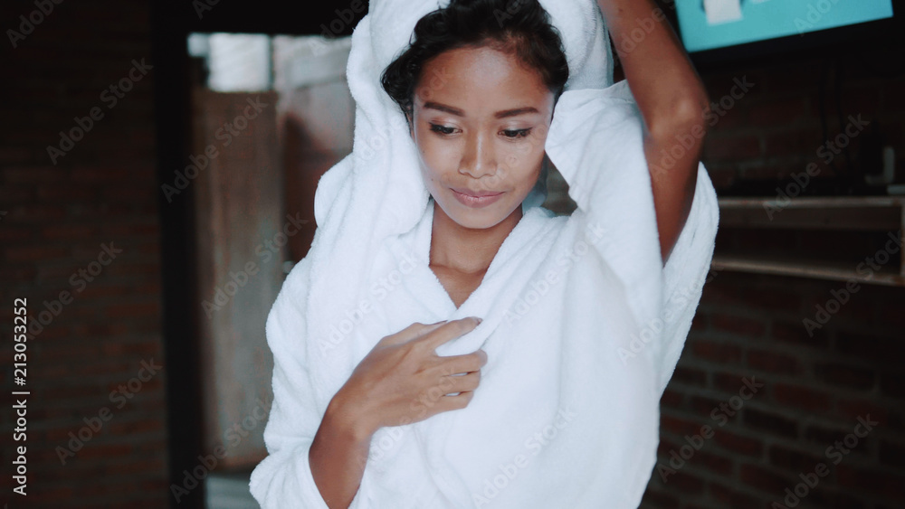 Fototapeta premium Beautiful lady going out from the bathroom covering her body and head with white towels. Portrait of fashion model girl indoors