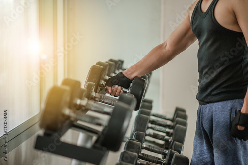 Rows of dumbbells in the gym with hign contrast and monochrome color tone.