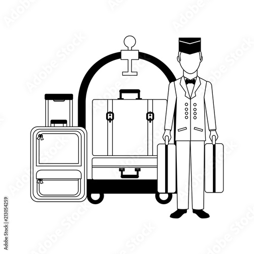hotel bellboy carrying suitcases and luggage trolley