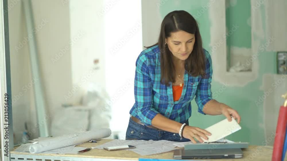 Woman looks angry while having problems with a project about her new house, steadycam shot
Woman looks angry while having problems with a project about her new house, steadycam shot