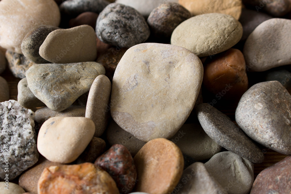 A lot of sea pebbles scattered around the table A lot of sea pebbles scattered around the table