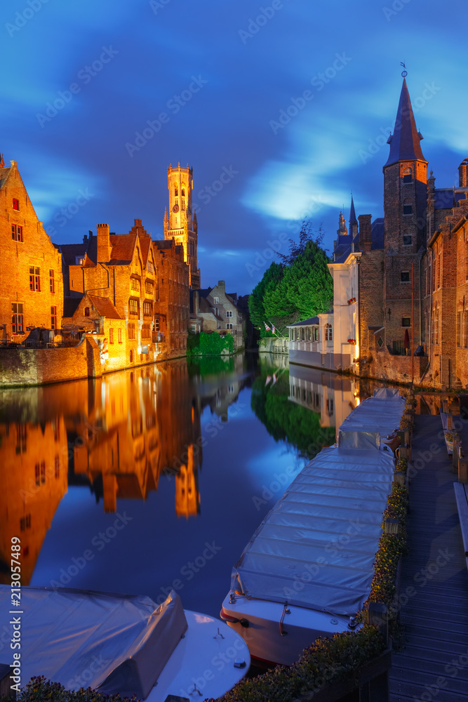 Fototapeta premium Scenic cityscape with a medieval fairytale town and tower Belfort from the quay Rosary, Rozenhoedkaai, at night in Bruges, Belgium