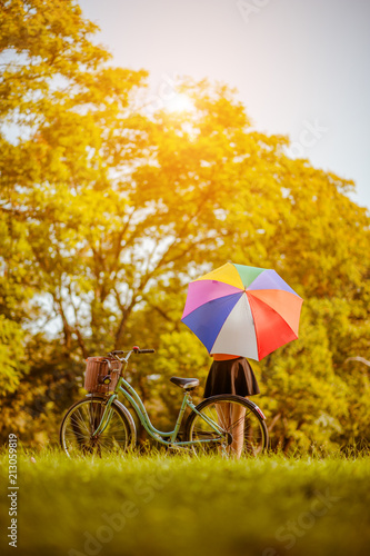 Relaxing woman at nature With colorful umbrellas and her bike.
