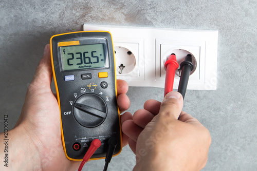Electrician checking voltage in socket