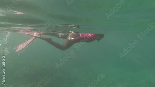 Girl is snorkeling at surface photo