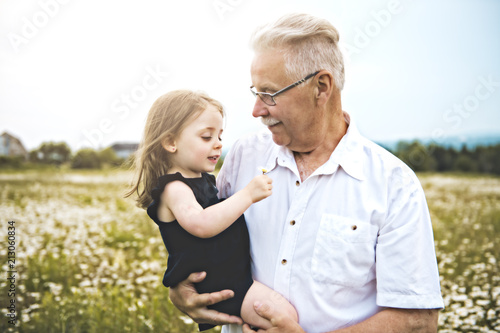 grandfather spending time with little child during the sunset.