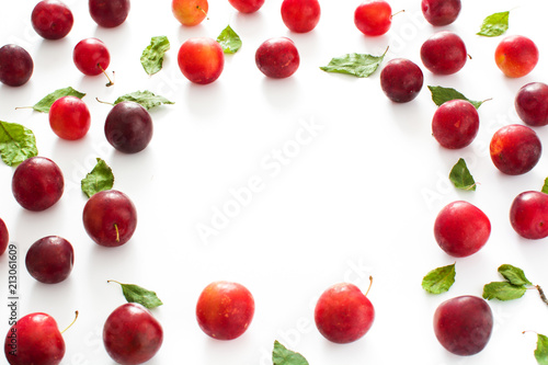 Red and yellow plums pattern on white background. Copyspace
