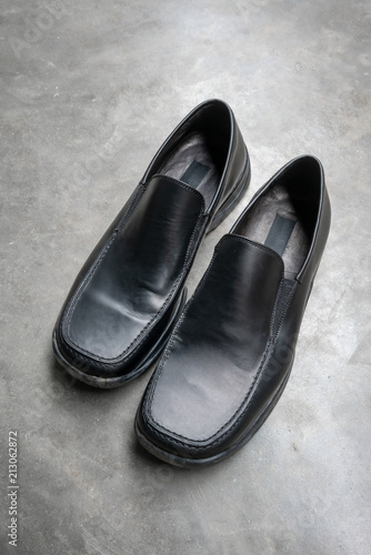 Black leather shoe on concrete floor