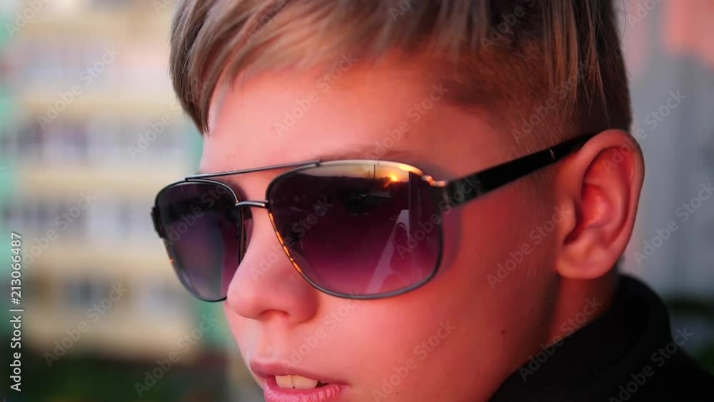 The guy with the sunglasses is watching the sunset. The sun's rays are reflected in the glass The guy with the sunglasses is watching the sunset. The sun's rays are reflected in the glass