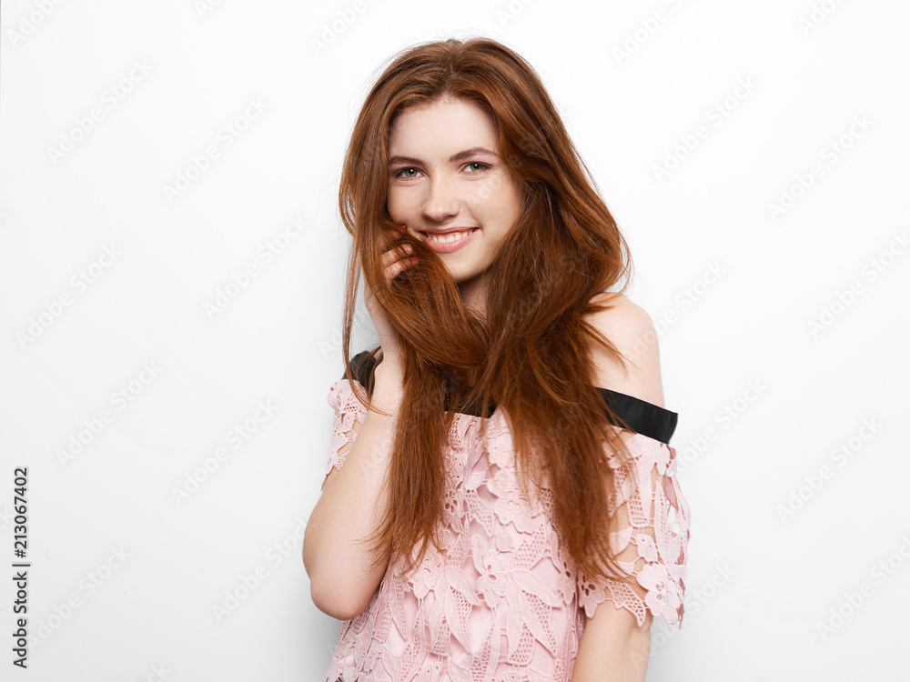 Young beautiful excited woman with bated breath touching her gorgeous natural ginger hair, blank copy space on white background for advertisment or promotional text Young beautiful excited woman with bated breath touching her gorgeous natural ginger hair, blank copy space on white background for advertisment or promotional text