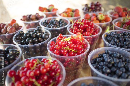 glasses with different berries-strawberries, currants, blueberries, gooseberries, raspberries © Igorzvencom