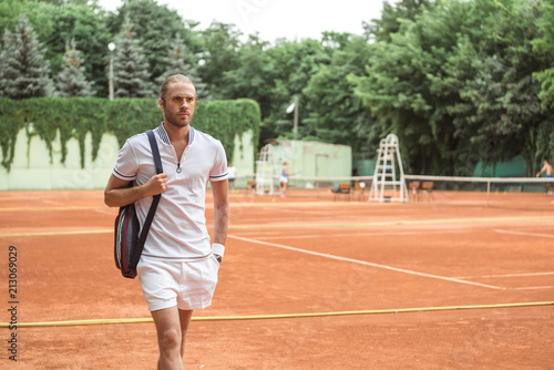 handsome tennis player after training on brown tennis court © LIGHTFIELD STUDIOS