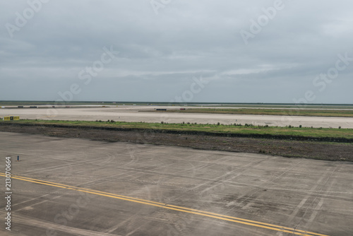 Empty airport runway on cloudy day