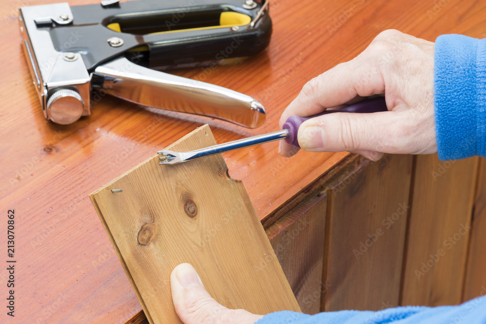 Persona que utiliza una herramienta para sacar los clavos de la madera foto  de Stock | Adobe Stock