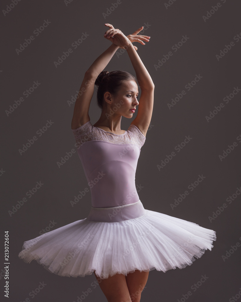 Fototapeta premium Young beautiful ballerina is posing in studio
