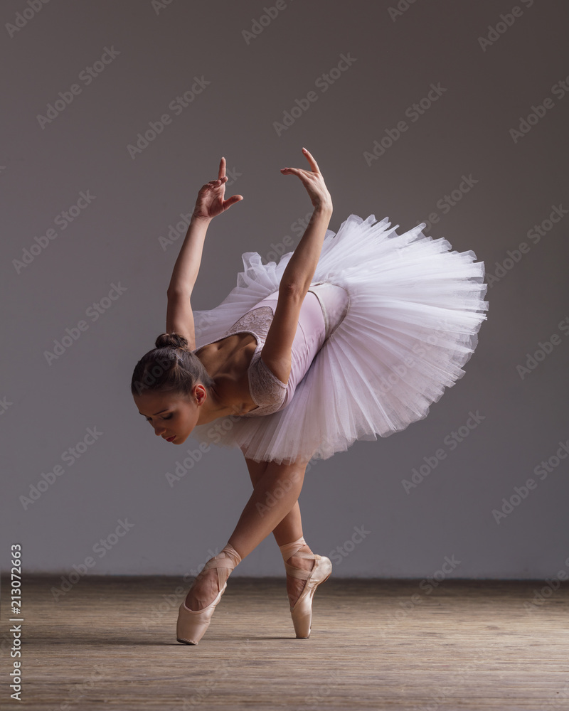 Photo & Art Print Young beautiful ballerina is posing in studio
