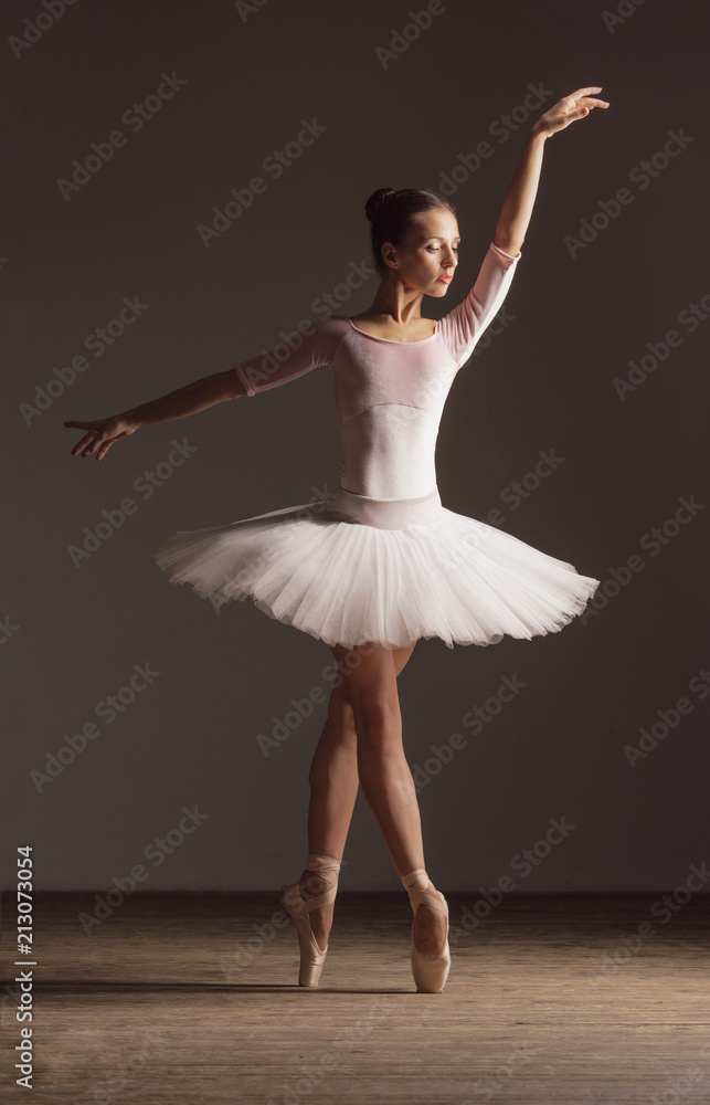 Naklejka premium Young beautiful ballerina is posing in studio