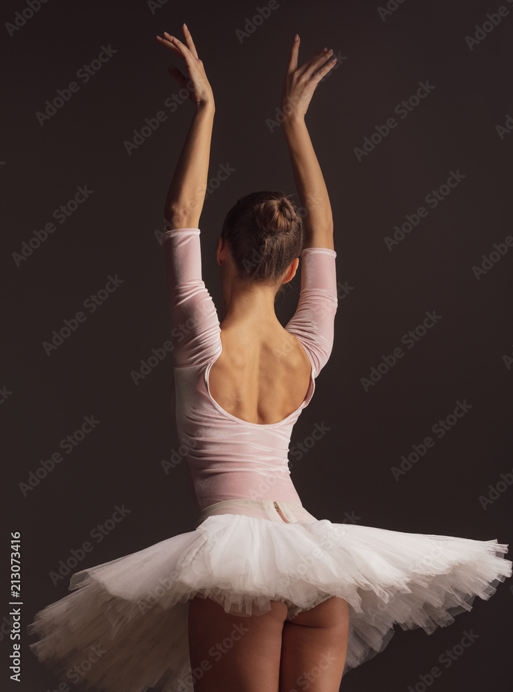 Fototapeta premium Young beautiful ballerina is posing in studio