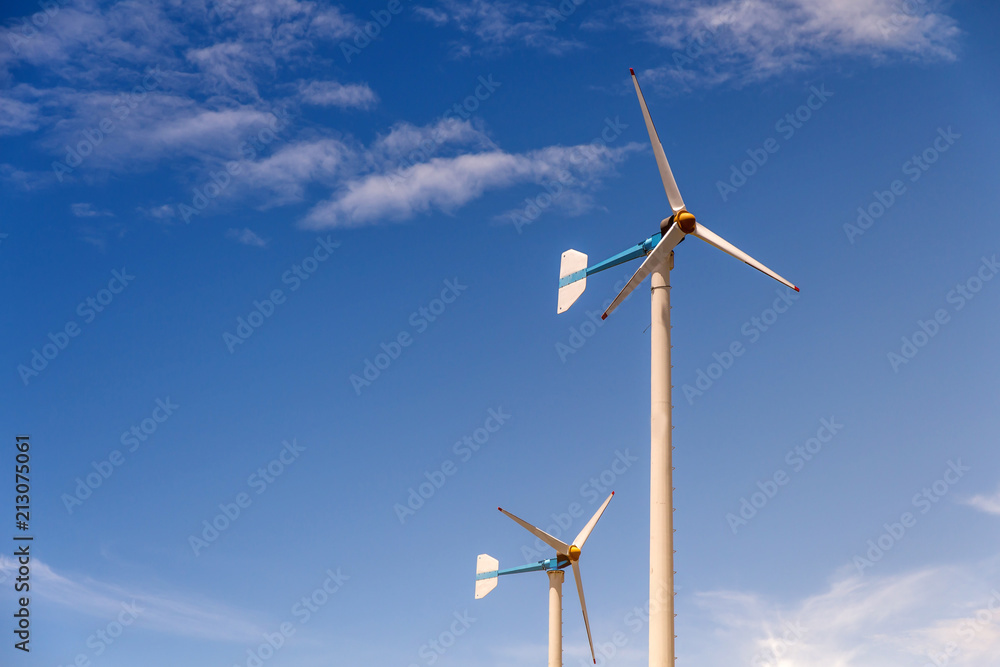 Wind turbine generating electricity on blue sky with clounds,Windmills for electric power ecology concept Wind turbine generating electricity on blue sky with clounds,Windmills for electric power ecology concept