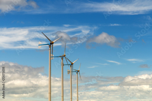 Wind turbine generating electricity on blue sky with clounds,Windmills for electric power ecology concept