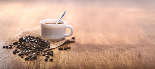 Leinwandbilder Kaffee Bar Weiße Kaffeetasse mit ganzen Bohnen  © guy
