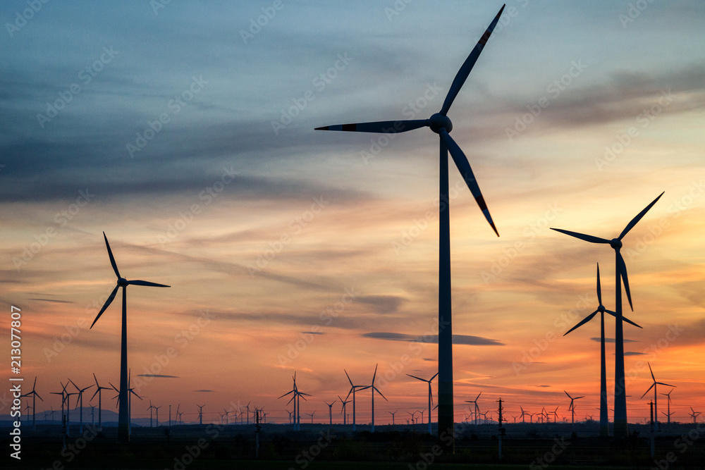 Group of wind power turbines at a sunset. Group of wind power turbines at a sunset.