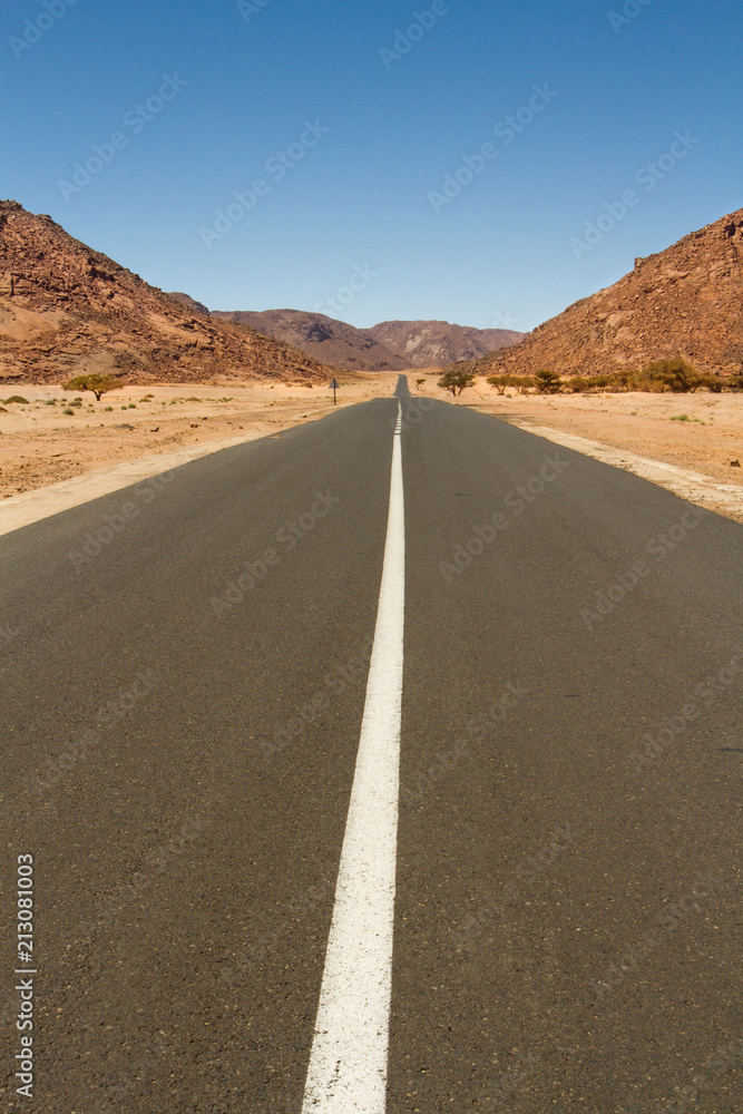 Empty straight and long road in the Sahara Desert, South Algeria, North Africa Empty straight and long road in the Sahara Desert, South Algeria, North Africa