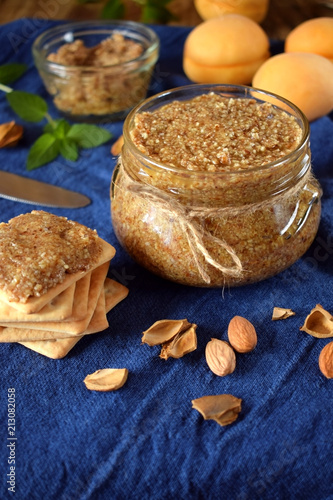 Urbech of apricot kernels in a glass jar and on a cracker