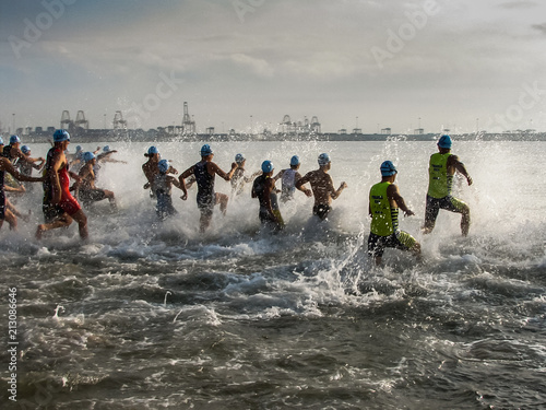Triathlon competition athletes enter to swim in the sea