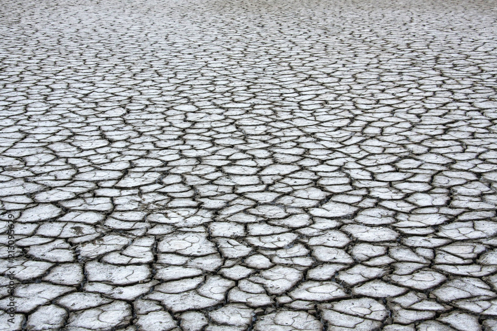 Dry gray ground with cracks covered with salt