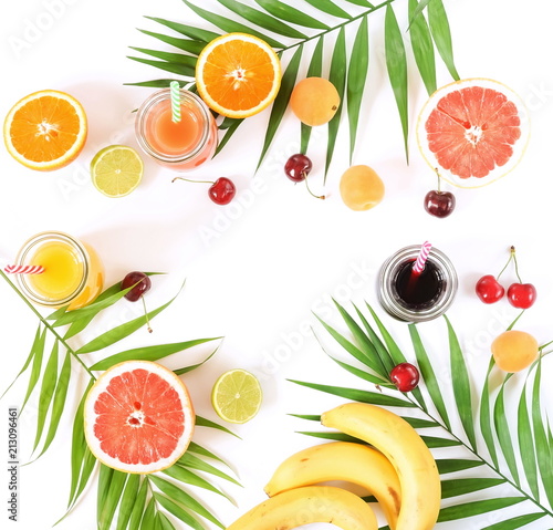 Assortment of natural juices in glass jars of oranges, grapefruit, cherries and various fruits on a white backgroundtop view. copy space
