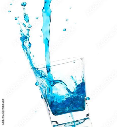 Splash from pouring blue water into the glass