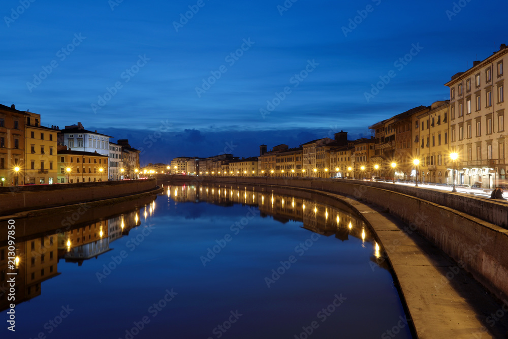 Pisa city, along river at night.