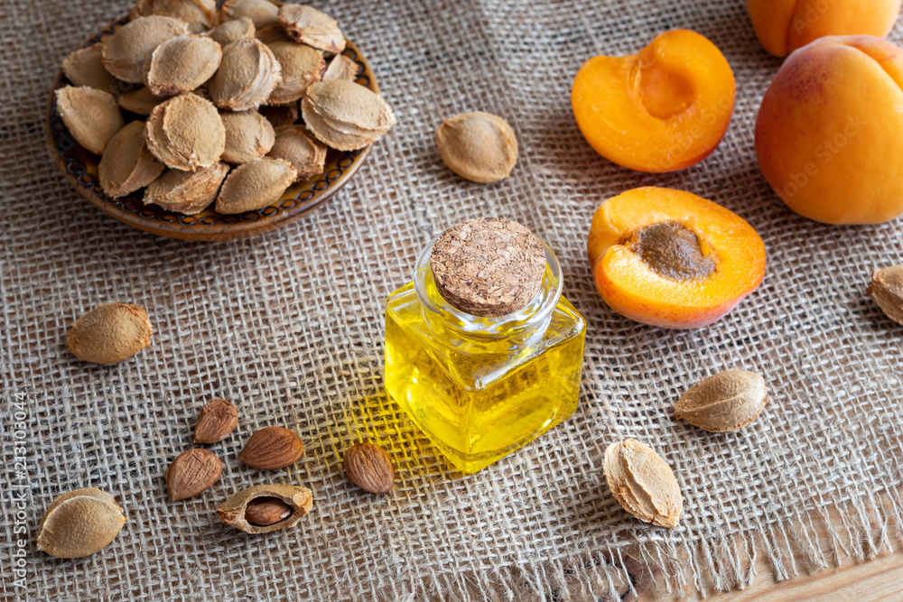 A bottle of apricot kernel oil with fresh ripe apricots A bottle of apricot kernel oil with fresh ripe apricots