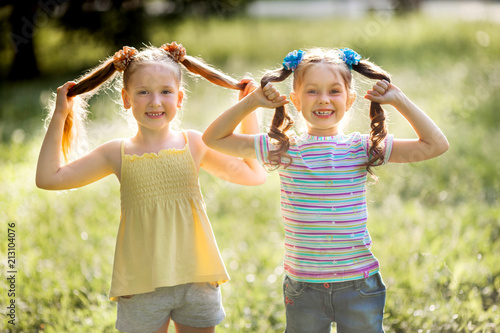 two beautiful young joyful girls in the summer in the park
