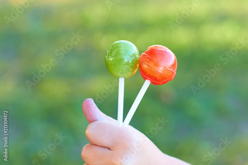 Lollipops on a stick in a child's hand. photo