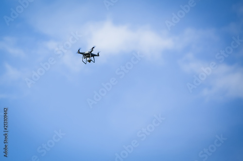 A drone hovering in a blue sky