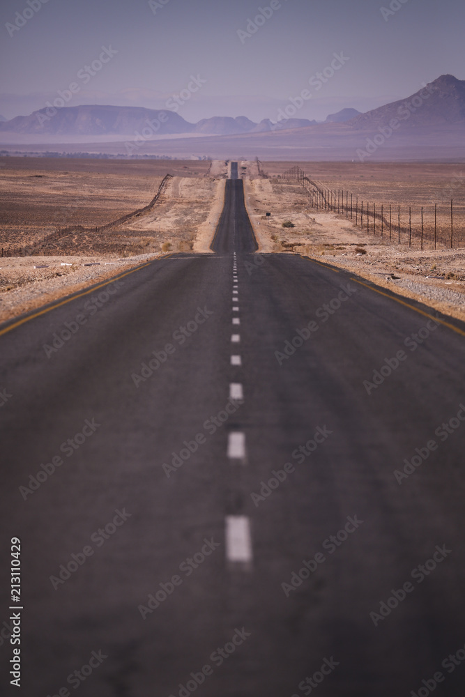 Long straight road running through a isolated desert in Namibia. 