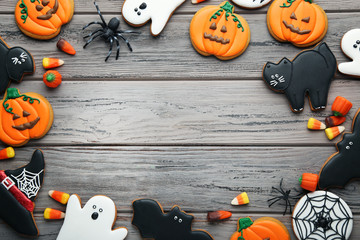 Halloween gingerbread cookies with candies on wooden table
