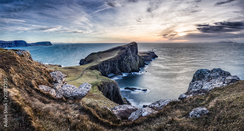 End of land. Rocky coastline of Scotland. Cliffs with lighthouse. Sunset scenery. Landscape nature. Romantic. Ocean, wind, breeze, cold.