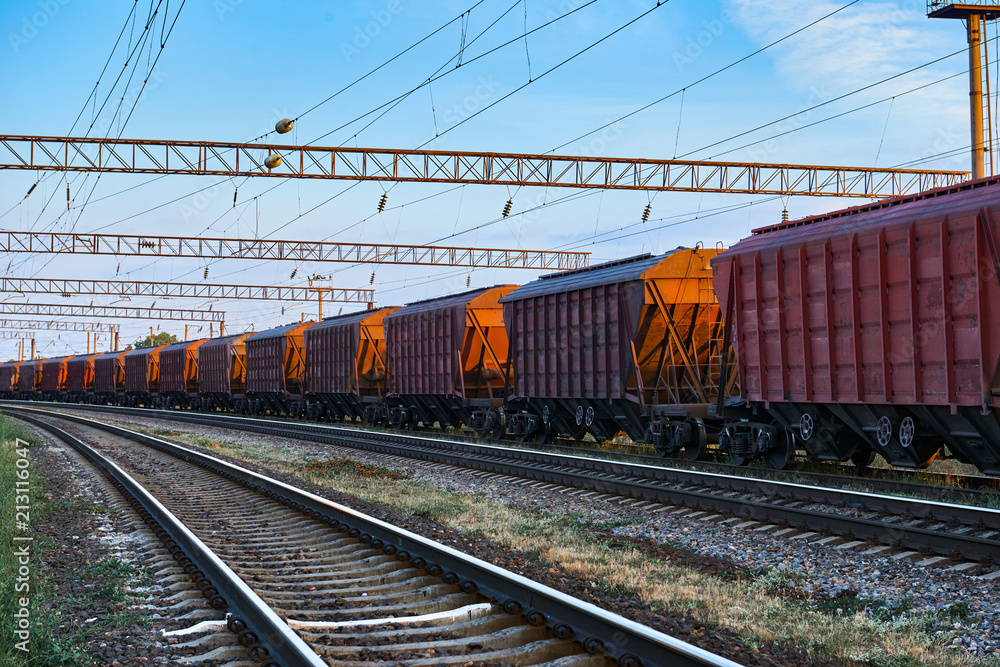 Naklejka premium infrastruktura kolejowa podczas pięknego zachodu słońca i kolorowe niebo, wagon do ładunków suchych, transport i koncepcja przemysłowa
