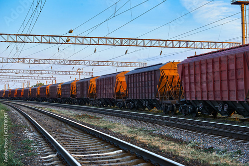 railroad infrastructure during beautiful sunset and colorful sky, railcar for dry cargo, transportation and industrial concept