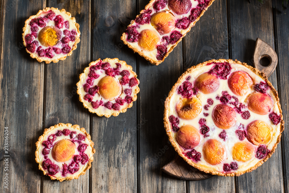 Rustic open pie with peach and raspberry, french galette . Peach tart. Raspberry tart. Tartalette with cream. Variety of bakery.