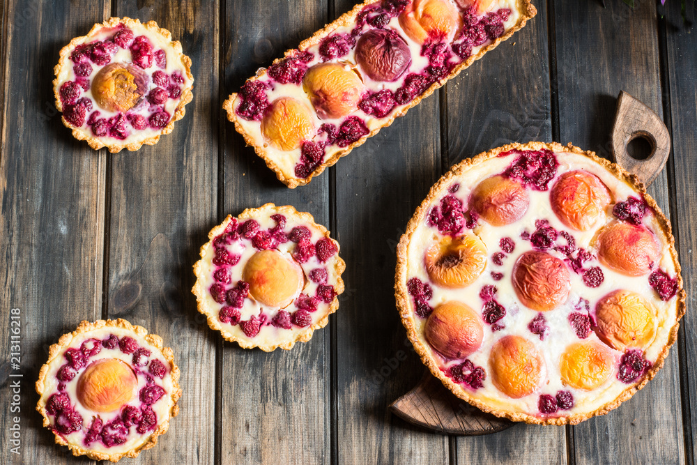 Rustic open pie with peach and raspberry, french galette . Peach tart. Raspberry tart. Tartalette with cream. Variety of bakery. Rustic open pie with peach and raspberry, french galette . Peach tart. Raspberry tart. Tartalette with cream. Variety of bakery.