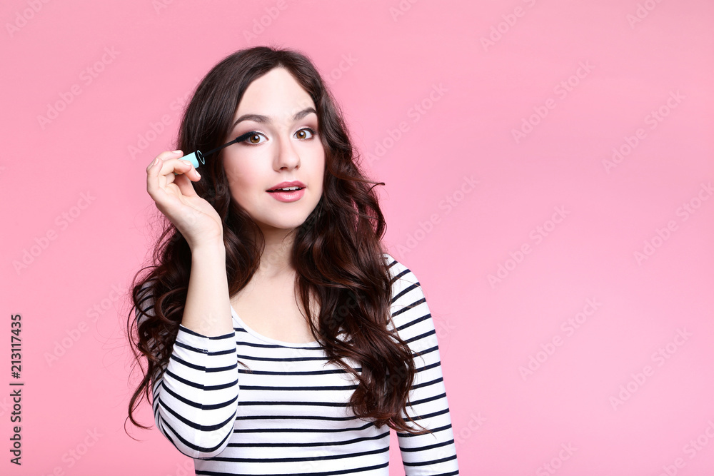 Beautiful woman with mascara on pink background Beautiful woman with mascara on pink background