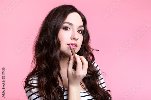 Beautiful woman with lipstick on pink background