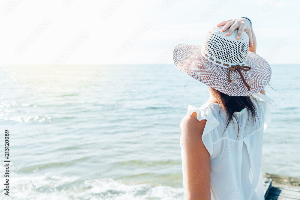 Donna che guarda il mare con cappello Stock Photo | Adobe Stock